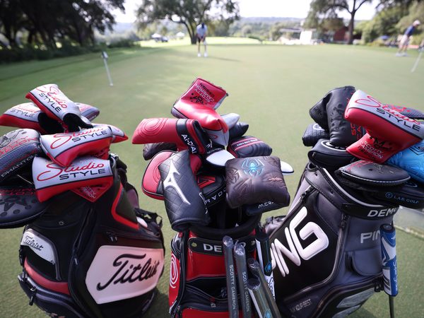 Demo bags of Scotty Cameron, Odyssey and PING putters on the practice green