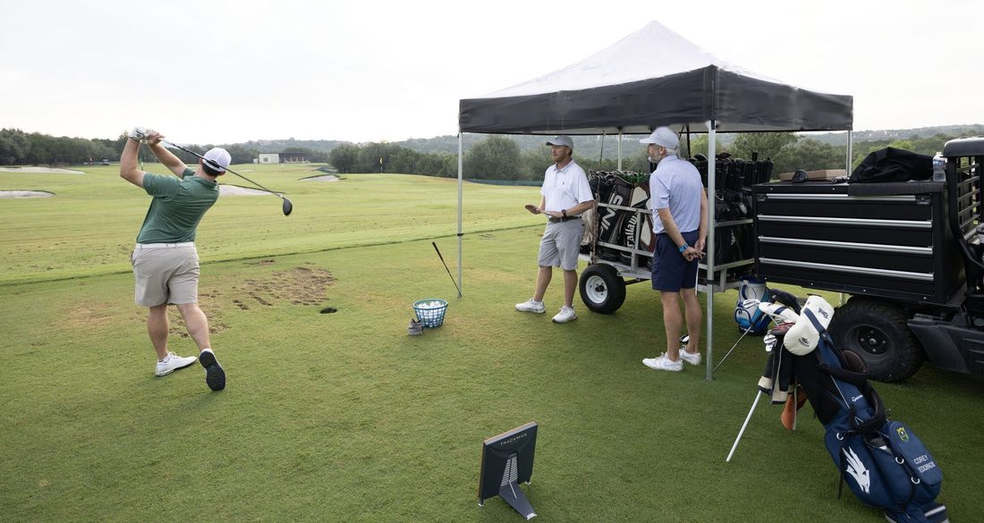 A driver fitting under the Next Gear canopy, with the Trackman unit in frame