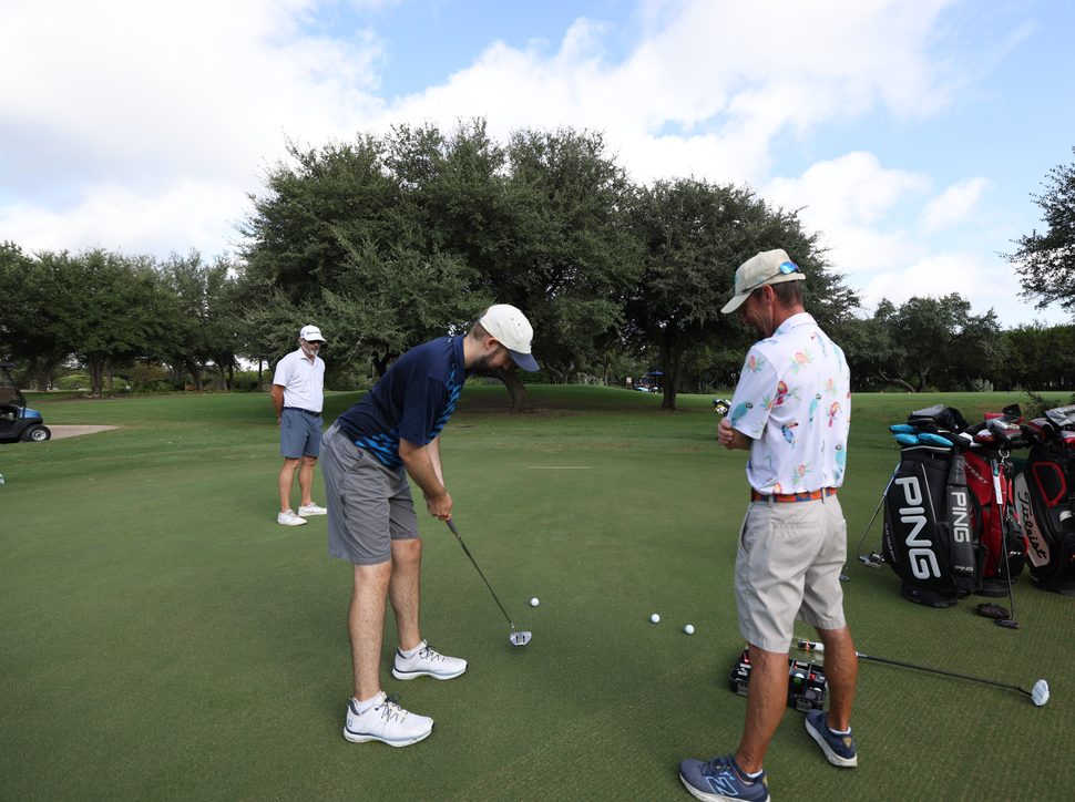 A Next Gear fitter working with a customer on the putting green at Barton Creek